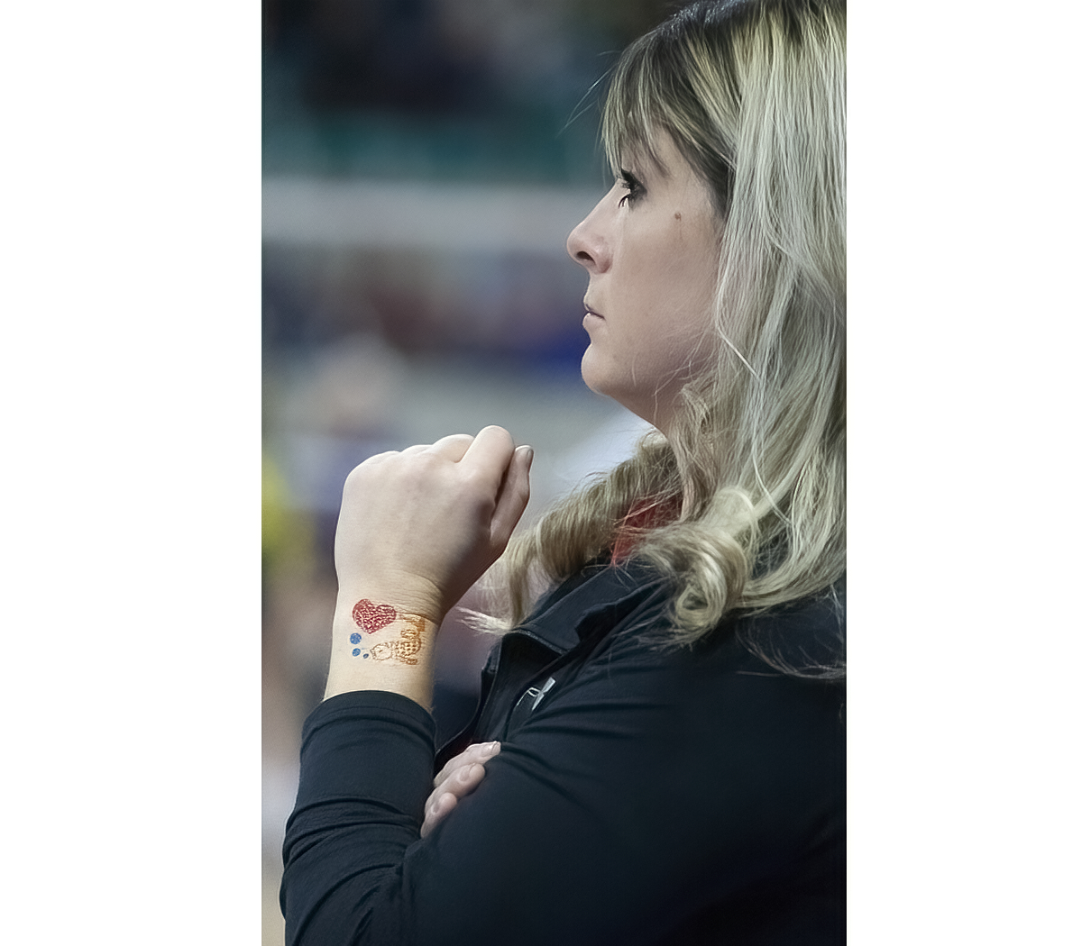 Head Coach Amber Huff, wearing the press-on tattoo that all the Lady Redhawks wore during the tourney, looks on with concern.